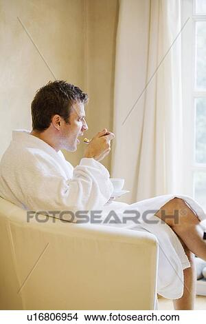 Picture - Man in bathrobe having breakfast. Fotosearch