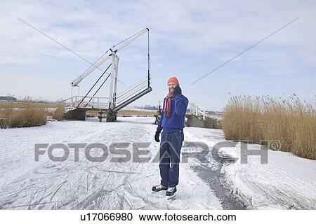 Man in ice skates talking on cell phone View Large Photo Image Stock Image - Man in ice skates talking on cell phone. Fotosearch