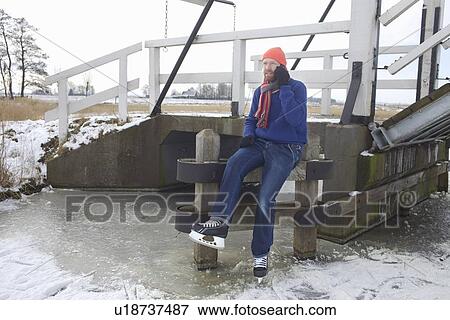 Man in ice skates talking on cell phone View Large Photo Image Stock Photo - Man in ice skates talking on cell phone. Fotosearch