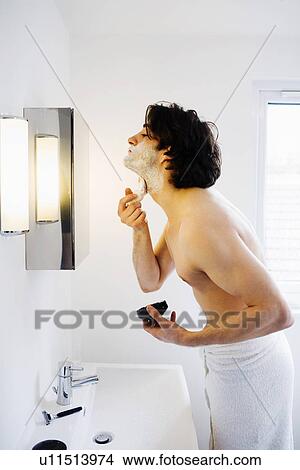 Man lathering shaving foam in bathroom View Large Photo Image Picture - Man lathering shaving foam in bathroom. Fotosearch