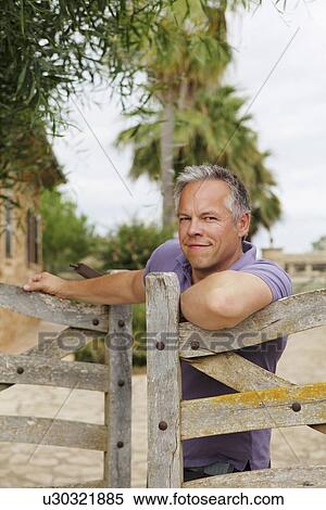 Man leaning on wooden fence outdoors View Large Photo Image Stock Photography - Man leaning on wooden fence outdoors. Fotosearch