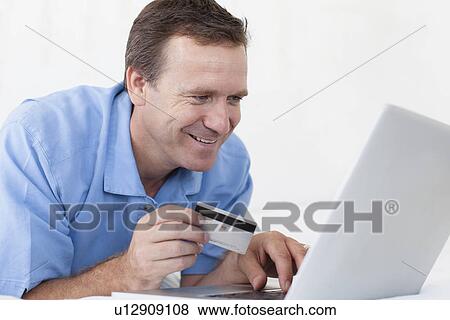 Man shopping online on bed View Large Photo Image Stock Photo - Man shopping online on bed. Fotosearch