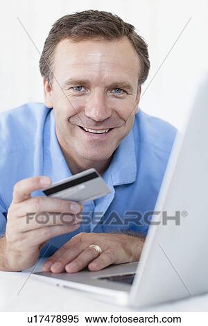Man shopping online on bed View Large Photo Image Stock Photography - Man shopping online on bed. Fotosearch