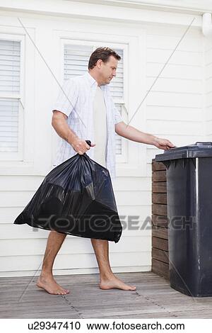 Stock Image - Man taking out garbage. Fotosearch