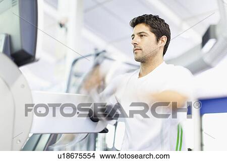Man using exercise machine in gym View Large Photo Image Picture - Man using exercise machine in gym. Fotosearch