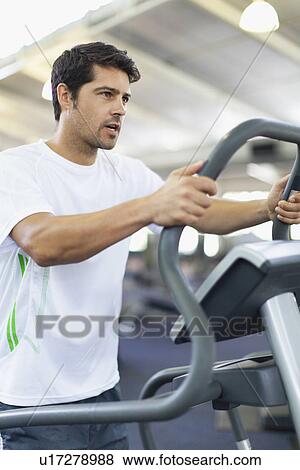 Man using exercise machine in gym View Large Photo Image Stock Photo - Man using exercise machine in gym. Fotosearch