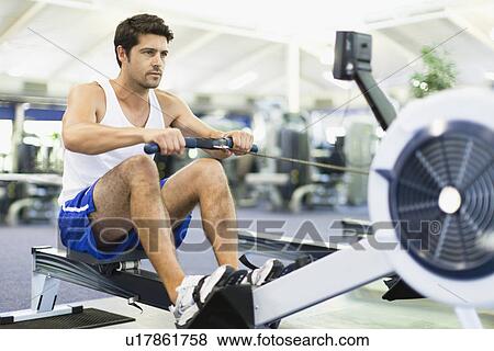 Man using rowing machine in gym View Large Photo Image Stock Photo - Man using rowing machine in gym. Fotosearch
