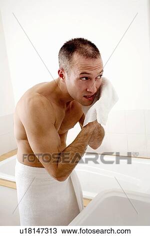 Stock Image - Man washing his face in bathroom. Fotosearch