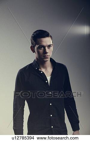 Man wearing button-up shirt indoors View Large Photo Image Picture - Man wearing button-up shirt indoors. Fotosearch