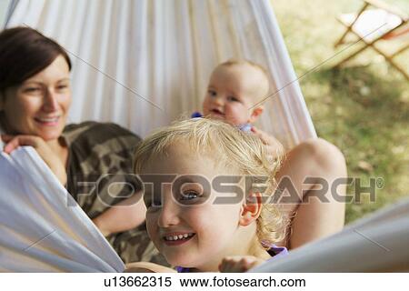 Stock Photography - Mother and children relaxing in hammock. Fotosearch