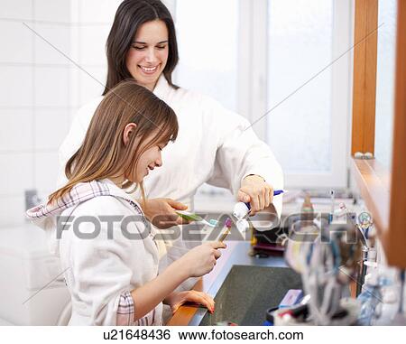 Stock Photograph - Mother and daughter brushing teeth. Fotosearch
