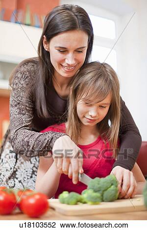 Stock Image - Mother and daughter cooking together. Fotosearch