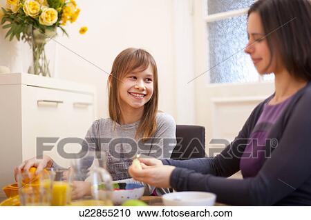 Stock Image - Mother and daughter having breakfast. Fotosearch