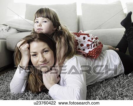Mother and daughter laying on rug View Large Photo Image Stock Image - Mother and daughter laying on rug. Fotosearch