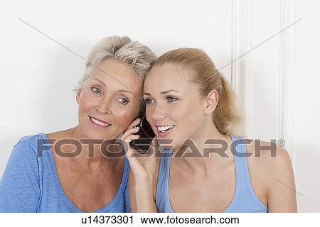 Stock Image - Mother and daughter on cell phone. Fotosearch