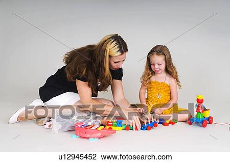 Mother and daughter playing together View Large Photo Image Stock Image - Mother and daughter playing together. Fotosearch