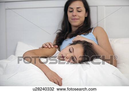 Mother and daughter relaxing in bed View Large Photo Image Stock Image - Mother and daughter relaxing in bed. Fotosearch