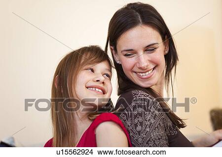 Mother and daughter sitting together View Large Photo Image Picture - Mother and daughter sitting together. Fotosearch