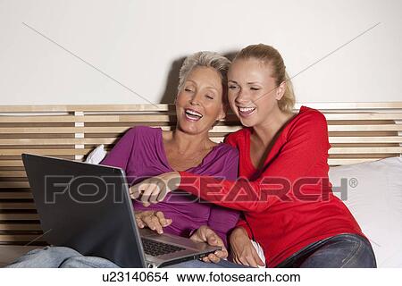 Mother and daughter using laptop View Large Photo Image Picture - Mother and daughter using laptop. Fotosearch