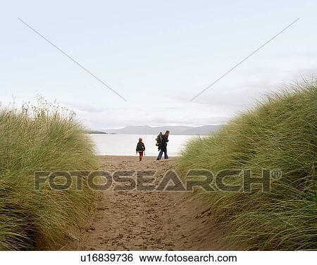 Stock Photograph - Mother and daughter walking on beach. Fotosearch