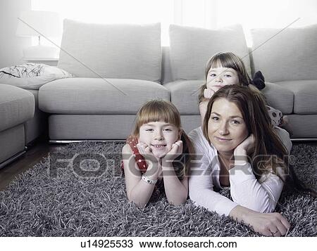 Mother and daughters laying on rug View Large Photo Image Stock Image - Mother and daughters laying on rug. Fotosearch