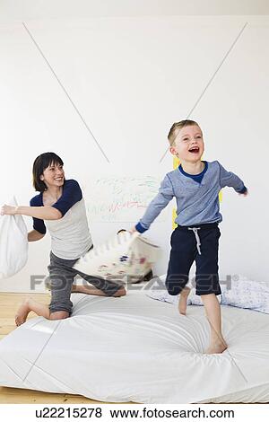 Stock Photo - Mother and son having pillow fight. Fotosearch