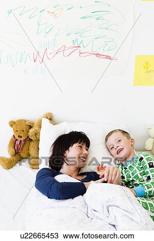 Mother and son laying in bed View Large Photo Image Stock Image - Mother and son laying in bed. Fotosearch