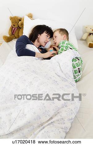 Mother and son laying in bed View Large Photo Image Stock Photo - Mother and son laying in bed. Fotosearch