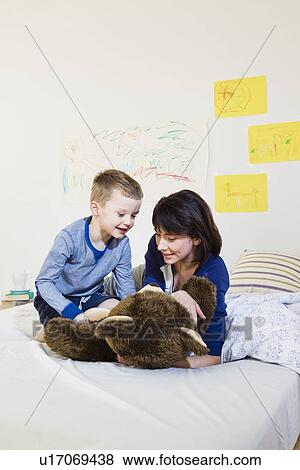 Mother and son playing on bed View Large Photo Image Stock Photo - Mother and son playing on bed. Fotosearch