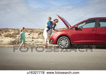 Mother examining broken down car View Large Photo Image Stock Photo - Mother examining broken down car. Fotosearch