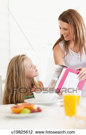 Mother pouring cereal for daughter View Large Photo Image Stock Image - Mother pouring cereal for daughter. Fotosearch
