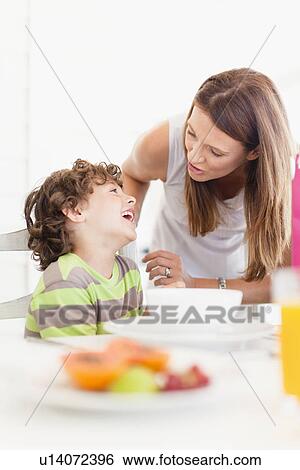 Mother talking to son at breakfast View Large Photo Image Stock Photograph - Mother talking to son at breakfast. Fotosearch