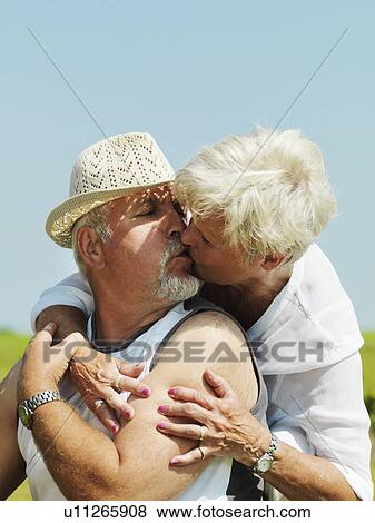 Stock Photo - Older couple kissing outdoors. Fotosearch