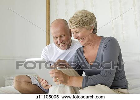 Stock Photography - Older couple using tablet computer. Fotosearch
