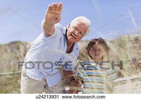 Older man and grandson standing outdoors View Large Photo Image Stock Image - Older man and grandson standing outdoors. Fotosearch