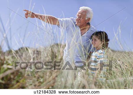 Older man and grandson standing outdoors View Large Photo Image Stock Photo - Older man and grandson standing outdoors. Fotosearch