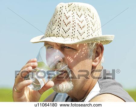 Older man drinking water outdoors View Large Photo Image Stock Image - Older man drinking water outdoors. Fotosearch