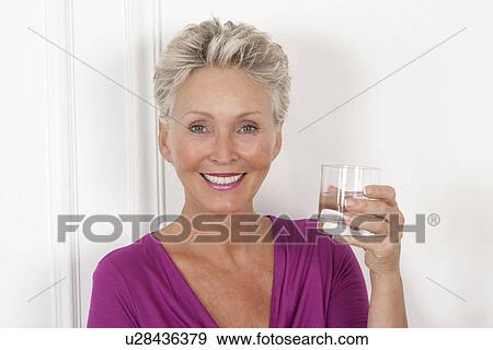 Older woman having glass of water View Large Photo Image Stock Photo - Older woman having glass of water. Fotosearch