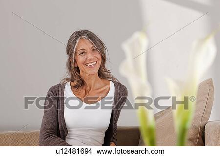 Older woman relaxing on sofa View Large Photo Image Picture - Older woman relaxing on sofa. Fotosearch