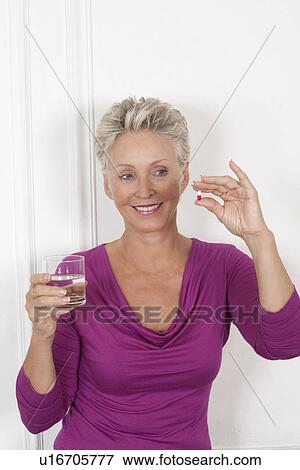 Older woman taking medication View Large Photo Image Stock Photo - Older woman taking medication. Fotosearch