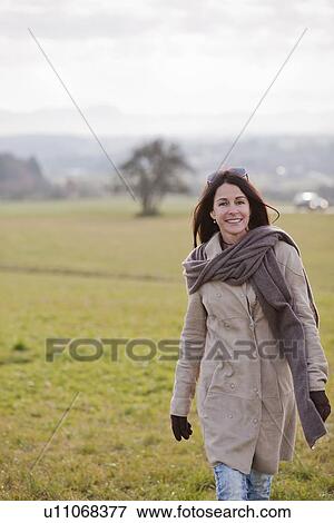 Stock Photo - Older woman walking in rural landscape. Fotosearch