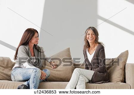 Older women relaxing together on sofa View Large Photo Image Stock Image - Older women relaxing together on sofa. Fotosearch