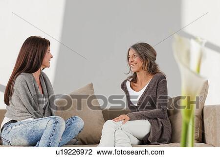 Older women relaxing together on sofa View Large Photo Image Stock Image - Older women relaxing together on sofa. Fotosearch