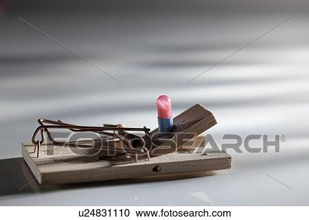 Stock Image - Pill on spring-loaded mouse trap. Fotosearch