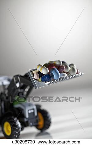 Stock Image - Pills on toy digger. Fotosearch