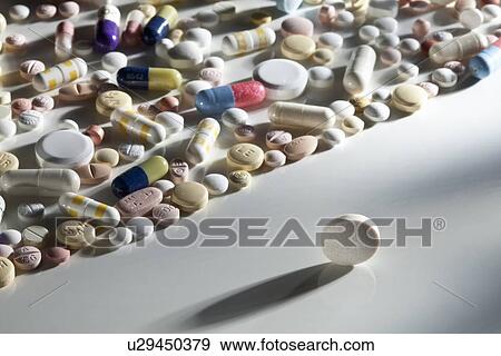 Stock Photo - Pills scattered on reflective surface. Fotosearch