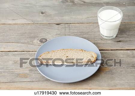 Stock Image - Plate of bread with glass of milk. Fotosearch