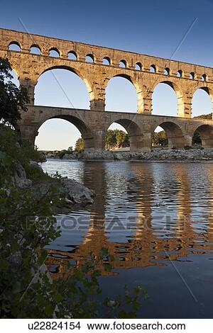 Picture - Pont du Gard bridge reflected in river. Fotosearch