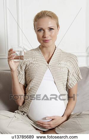 Pregnant woman having glass of water View Large Photo Image Stock Photo - Pregnant woman having glass of water. Fotosearch