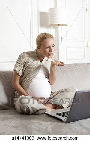Stock Photo - Pregnant woman in video chat. Fotosearch